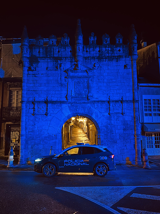 Edificio histórico iluminado con el color azul de la Policía Nacional.